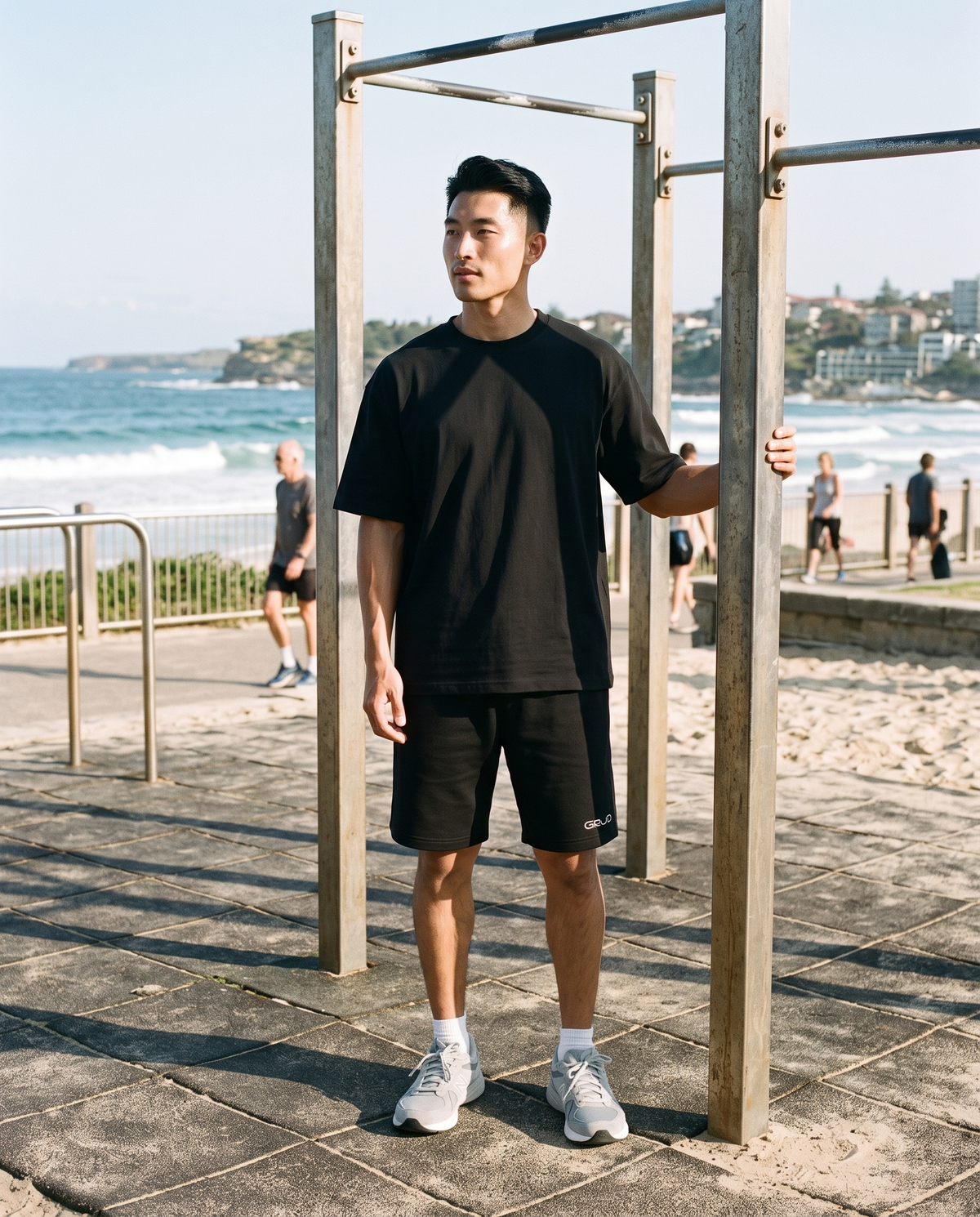GRUD Oversized Shorts in black worn at a beachside outdoor gym