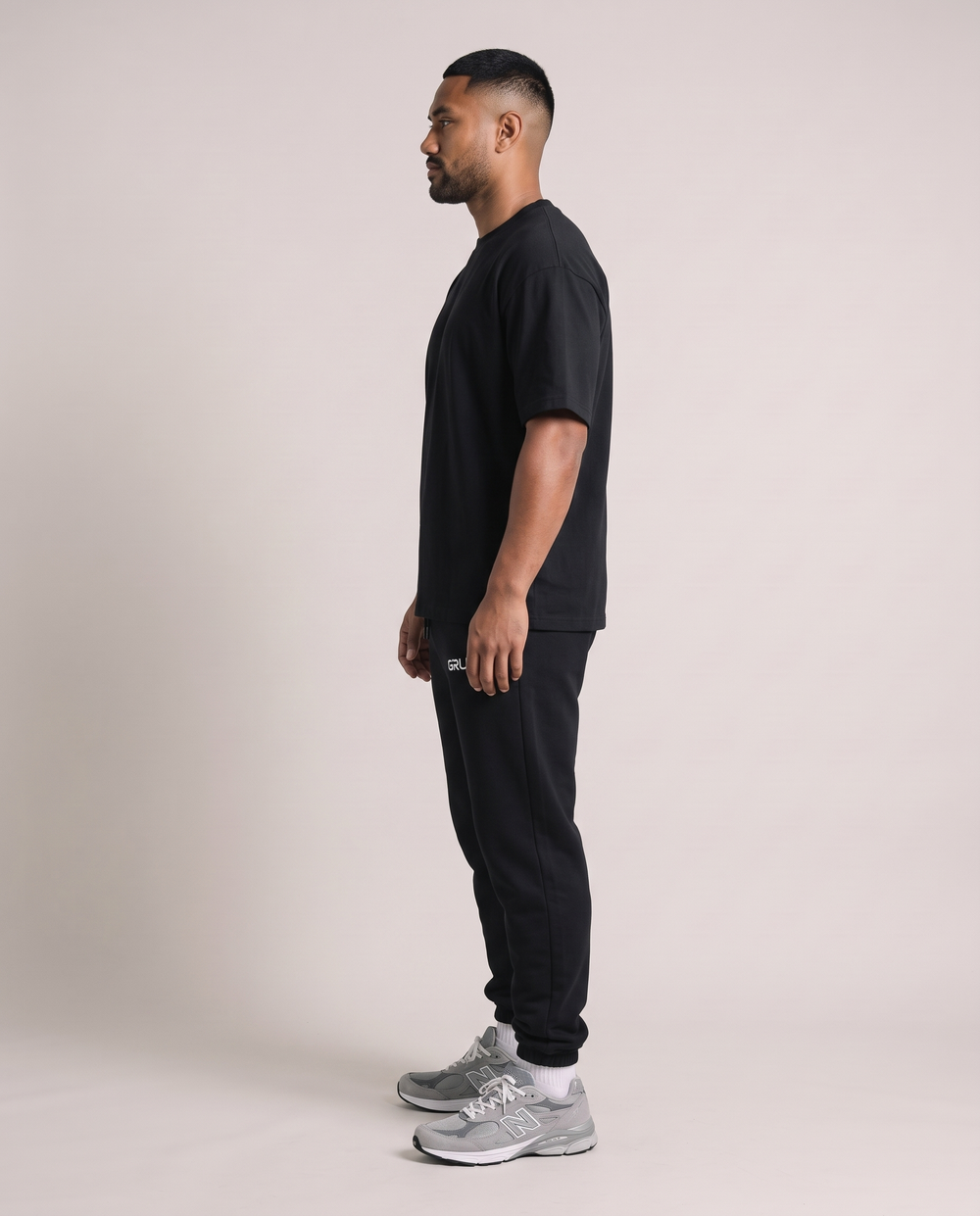 GRUD Essentials Sweat Pants in black, side profile showing the tapered leg