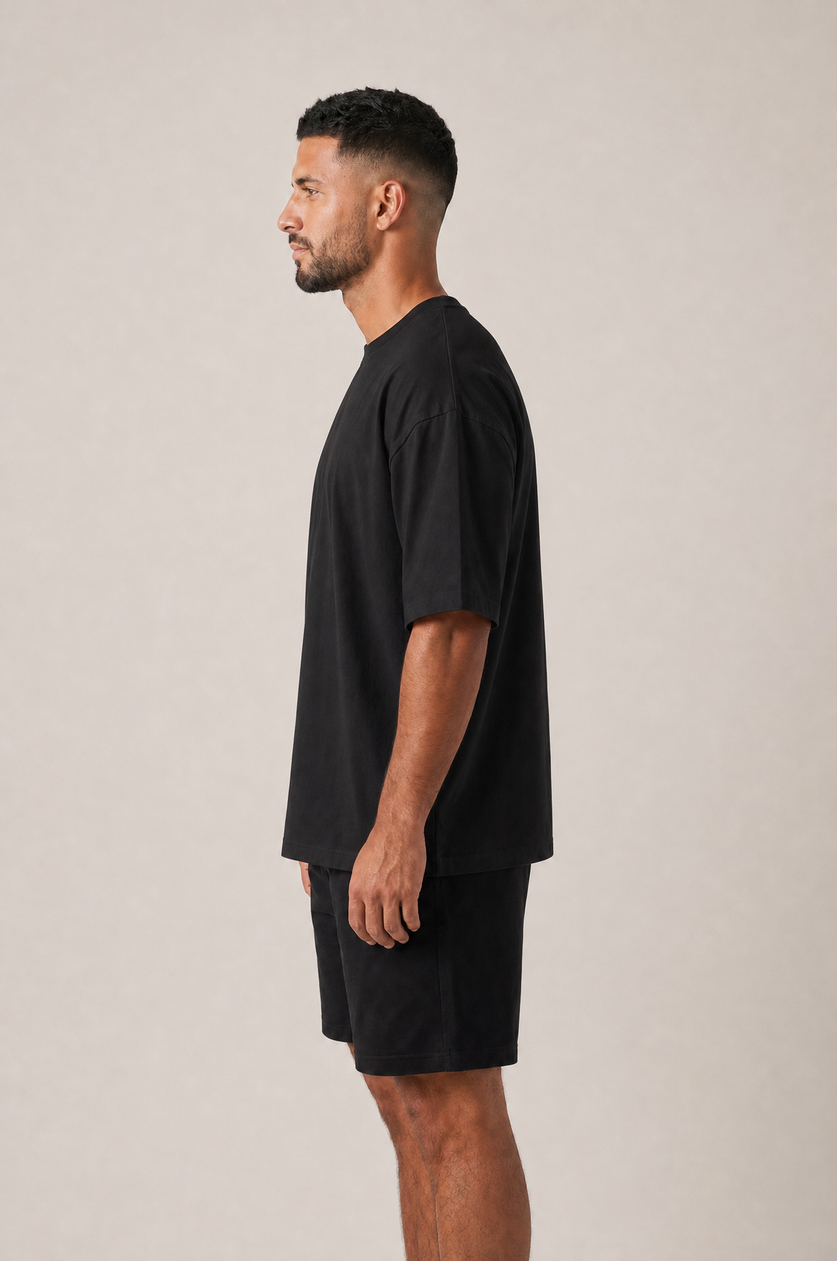 Model wearing the GRUD Heavyweight Oversized Tee in black, side view showing the dropped shoulder