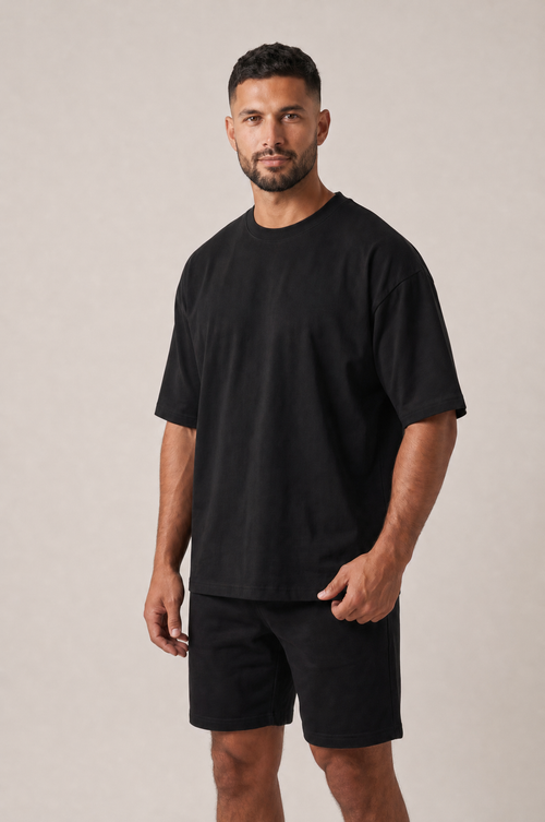 Model wearing the GRUD Heavyweight Oversized Tee in black, three-quarter view showing the dropped shoulders